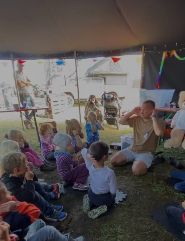 Kind übt spielerisch Erste Hilfe am Teddybären unter Anleitung von Tom Mentler